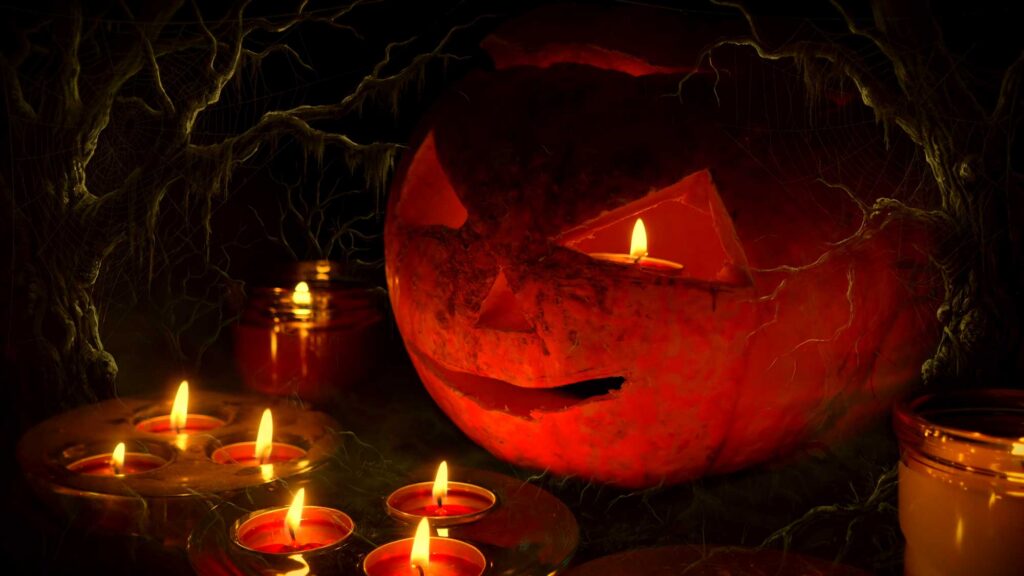 Halloween pumpkin surrounded by surrounded by candles.