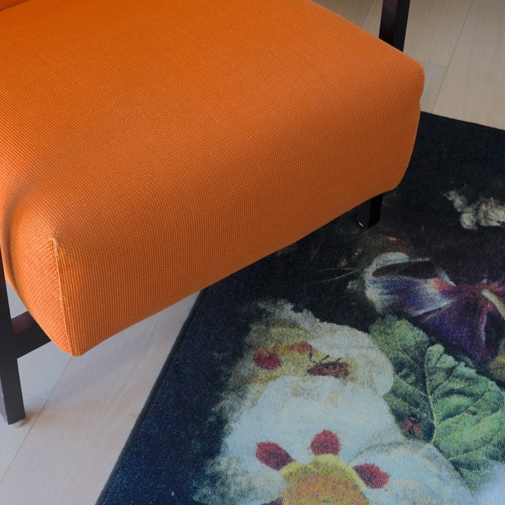 A close up of a chair and a rug and wooden floor. Photography by Vanity Pix.