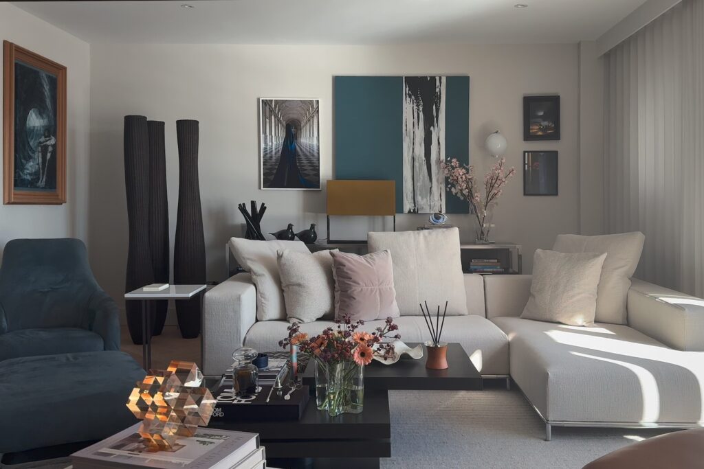 A modern, sophisticated living room interior featuring a large, light-colored L-shaped sectional sofa as the central focus. Photography by Vanity Pix.